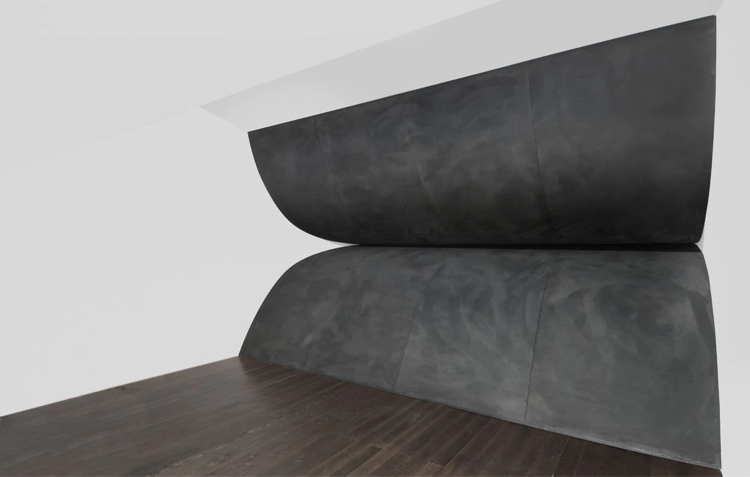 Un Orizzonte, two monumental dark curved forms meeting in a gallery