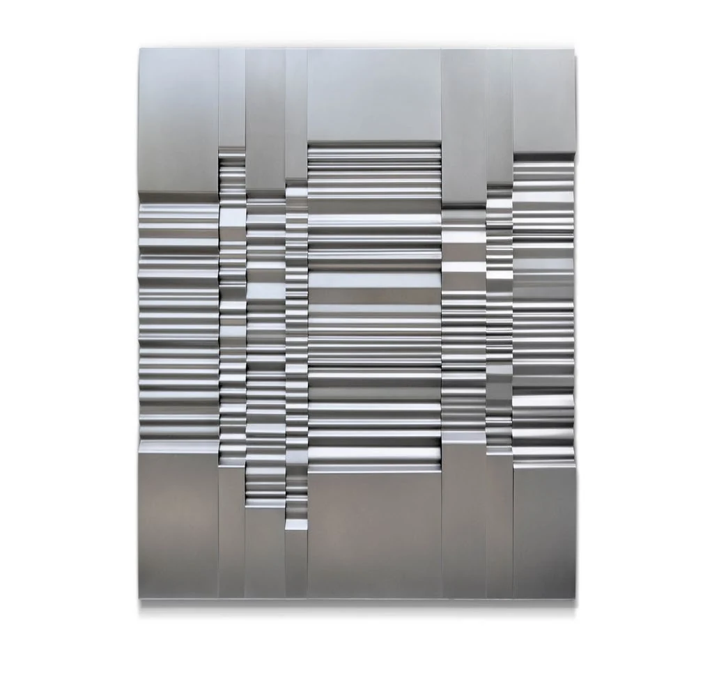A stainless steel relief made of rhythmic horizontal folds