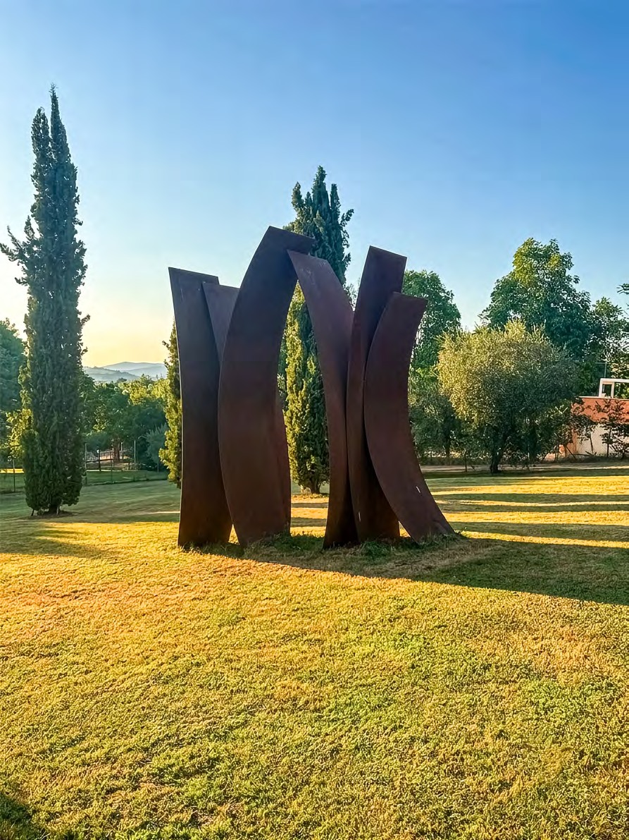A monumental group of curved Cor-Ten steel planes installed in a park